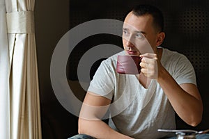 Portrait of handsome man drinking coffee in the living room