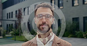 Portrait of handsome man in glasses with beard looking to camera. Close up of male person in stylish outfit with serious