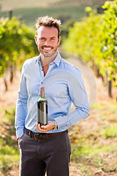 Portrait of handsome man holding wine bottle