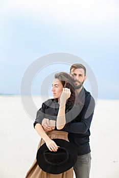 Portrait of handsome man hugging woman in monophonic background.