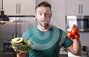 Portrait of handsome man in kitchen. Young man preparing delicious and healthy food in home kitchen. Man with recipe