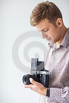 Portrait of handsome man with old medium format camera