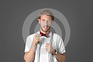 Portrait of handsome man pointing at viewer on grey background