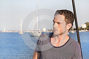 Portrait of handsome man standing on a sailing boat