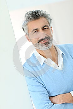 Portrait of handsome mature man leaning on wall