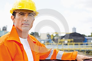 Portrait of handsome mid adult man wearing protective workwear at construction site