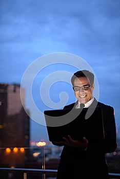 Handsome Persian businessman against view of the city at night