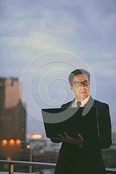 Handsome Persian businessman against view of the city at night