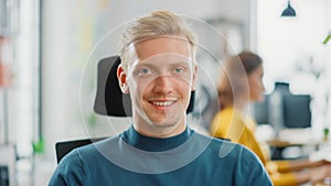 Portrait of Handsome Professional Caucasian Man Working at His Desk, Looking Smilingly at the Came photo