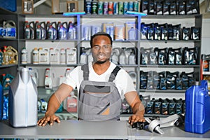 Portrait of a handsome african salesman in an auto parts store. The concept of car repair