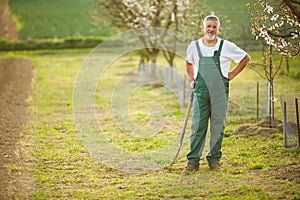 Portrait of a handsome senior man gardening in his garden