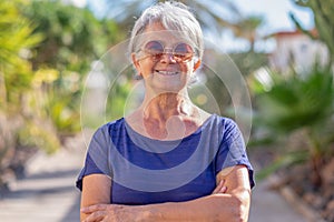 Portrait of handsome senior woman in outdoor, looking at camera smiling