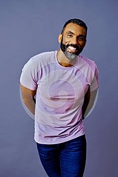 portrait of a handsome smiling african american man with beard and mustache purple shirt on a gray background