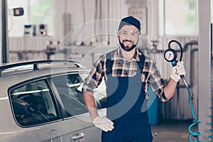 Portrait of handsome, smiling auto mechanic in blue overall, ch