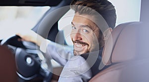 Portrait of an handsome smiling business man driving his car