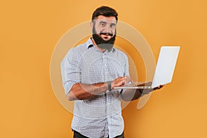 Portrait of handsome smiling man isolated on yellow studio background posing to the camera and making funny faces, got idea, point