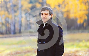 Portrait handsome smiling man wearing a black coat jacket in sunny autumn