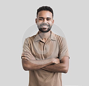 Portrait of handsome smiling young man with folded arms. Laughing joyful cheerful men with crossed hands isolated studio shot