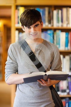 Portrait of a handsome student holding a book