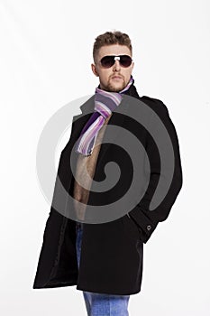 Portrait of handsome stylish blond man in sunglasses and a coat