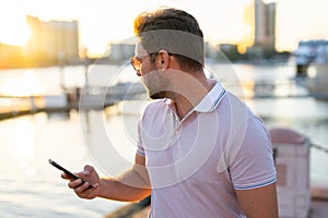 Portrait of handsome stylish man chatting on phone in big city. Sexy man in casual clothes talking on phone on the