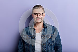 Portrait of handsome stylish young man in glasses posing to the camera