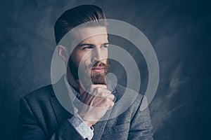 Portrait of handsome stylish young man with mustache, beard and beautiful hairstyle keep calm and think while hold beard