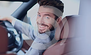 Portrait of an handsome smiling business man driving his car