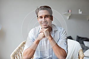 Portrait of handsome successful man, young person is sitting in comfortable armchair