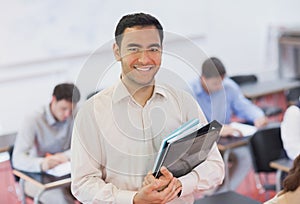 Portrait of handsome teacher posing in his classroom
