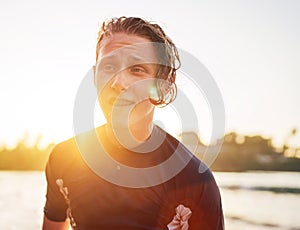 Portrait of a handsome teen boy surfing rashguard on the sand Indian ocean beach with sunset on background. Happy teen time and