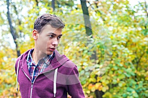 Portrait of a handsome teenage boy in an autumn forest