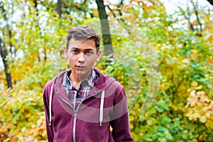 Portrait of a handsome teenage boy in an autumn forest