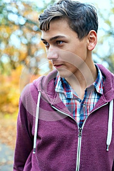 Portrait of a handsome teenage boy in an autumn forest