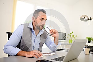 Portrait of handsome trendy casual mid age business man in office desk with laptop computer