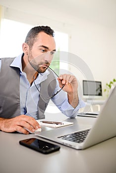 Portrait of handsome trendy casual mid age business man in office desk with laptop computer