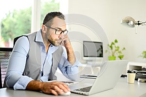 Portrait of handsome trendy casual mid age business man in office desk with laptop computer