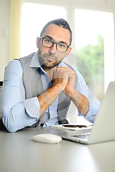 Portrait of handsome trendy casual mid age business man in office desk with laptop computer