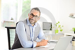 Portrait of handsome trendy casual mid age business man in office desk with laptop computer