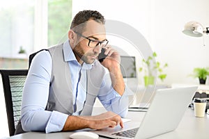 Portrait of handsome trendy casual mid age business man in office desk with laptop computer