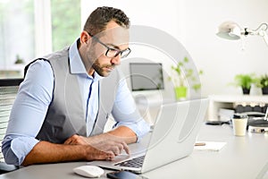 Portrait of handsome trendy casual mid age business man in office desk with laptop computer
