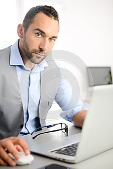 Portrait of handsome trendy casual mid age business man in office desk with laptop computer