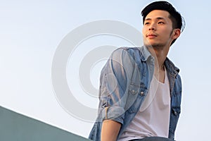 Portrait handsome young asian man  He looking to beautiful sunset, it make him happy. Attractive men feel relax, determined. Cool