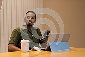 Portrait of handsome young black man using laptop computer in coffee shop