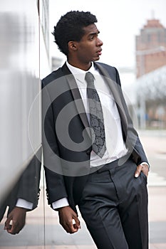 Portrait of a handsome young black man wearing a business suit in the city