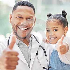 Portrait of handsome young black paediatrician holding adorable little boy in hands, cute child and doctor smiling