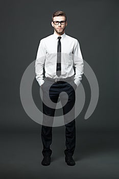 Portrait of handsome young businessman on dark background.