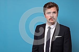Portrait of a handsome young businessman with mustache in suit