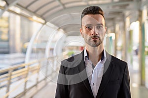 Portrait of handsome young businessman outdoors in city