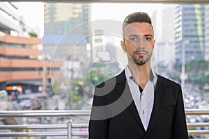 Portrait of handsome young businessman outdoors in city